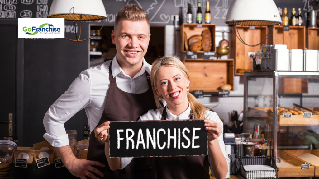 A man and a woman holding up a sign that says 'Franchise'